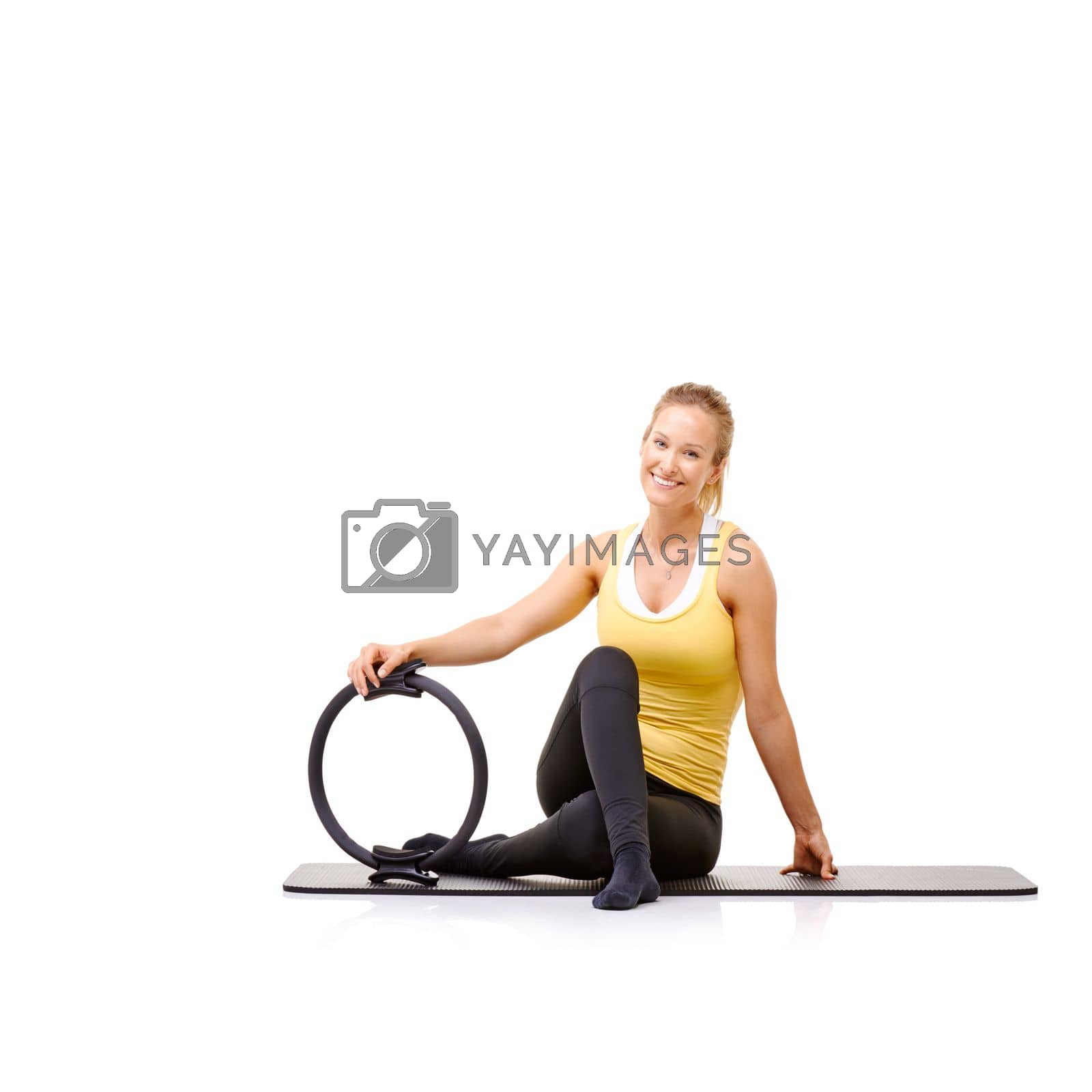 Royalty free image of She loves using her pilates ring. A beautiful young woman sitting on her exercise mat holding a pilates ring. by YuriArcurs