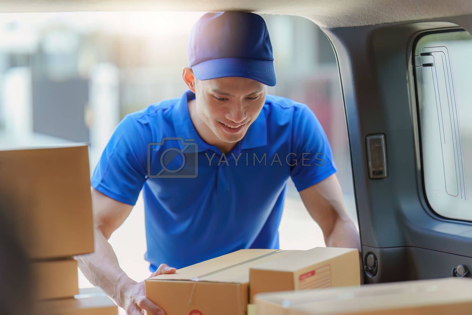 Royalty free image of Asian courier with parcel and delivery logistic concept. Delivery man holding parcel box by itchaznong