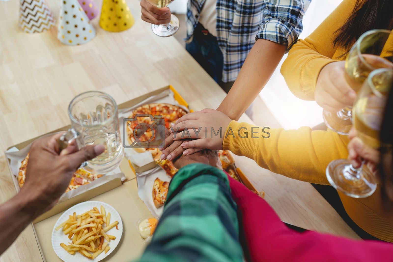 Royalty free image of Friends at birthday party clinking glasses with champagne and pizza, enjoying Christmas vacation, pizza on the table. Holiday Party event. by itchaznong