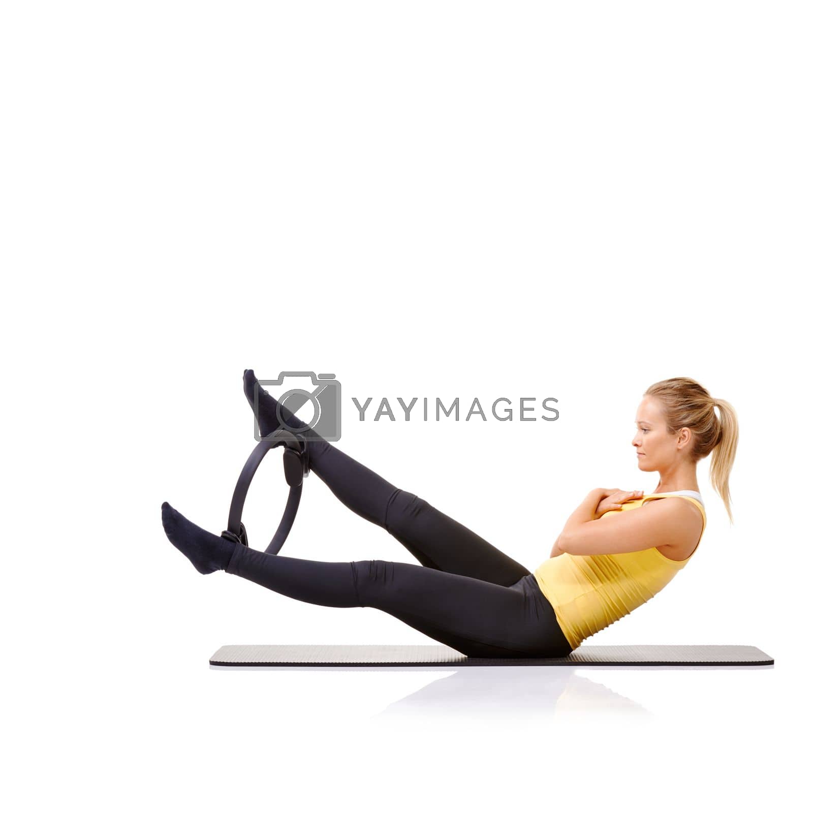 Royalty free image of Balance and stamina - Pilates Ring Exercises. A pretty young blonde working her legs out with a pilates ring. by YuriArcurs