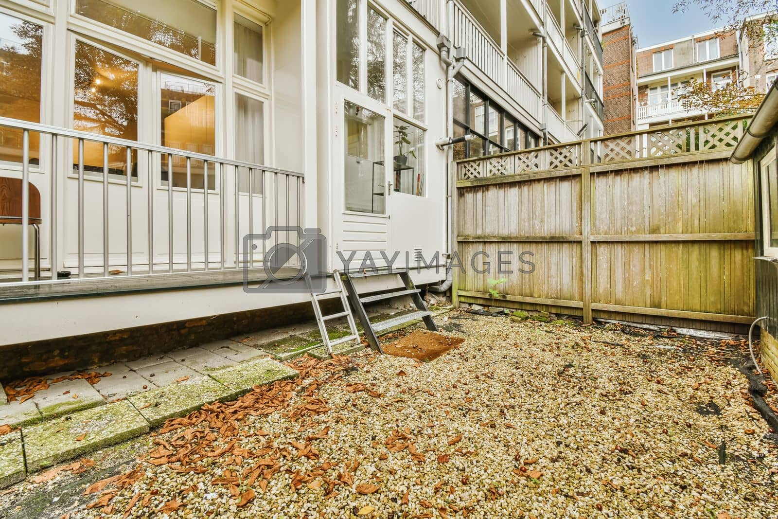Royalty free image of the back yard of a house with a wooden fence by casamedia