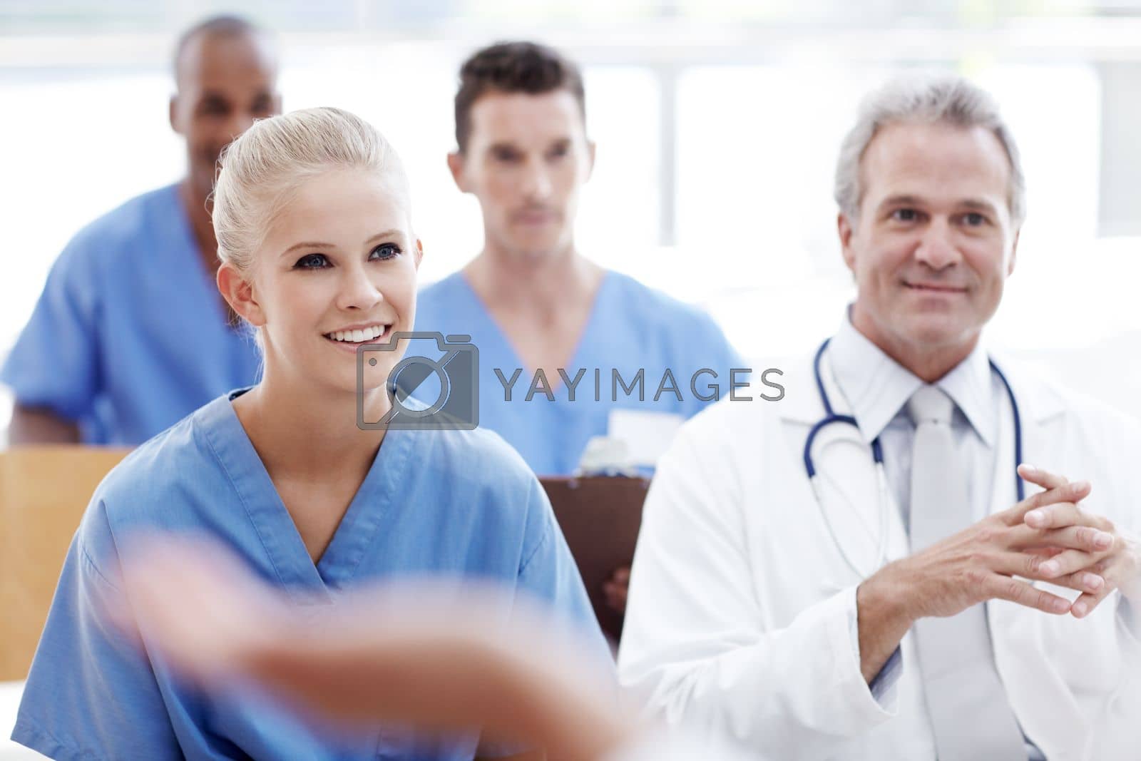 Royalty free image of All ears for the latest descoveries in healthcare. Doctors and nurses in a seminar together. by YuriArcurs