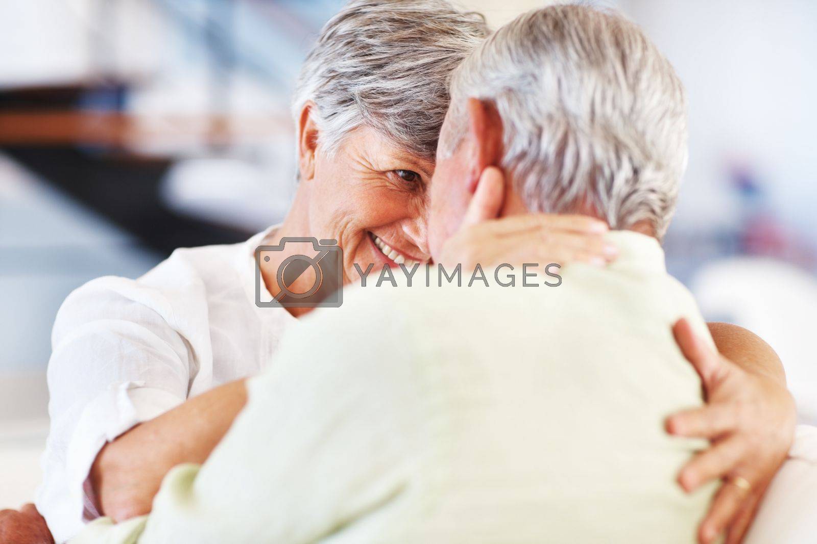 Royalty free image of Romance at home. Smiling mature woman and man looking at each other while spending romantic time. by YuriArcurs