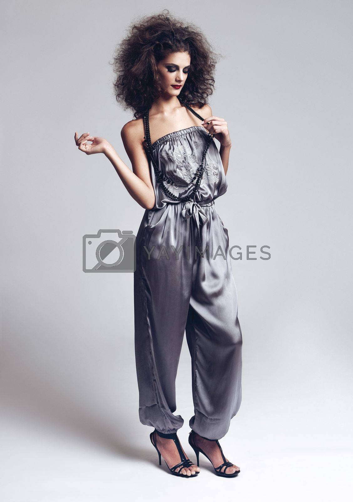 Royalty free image of Taking fashion to the next level. Studio portrait of a beautiful young fashion model standing against a gray background. by YuriArcurs
