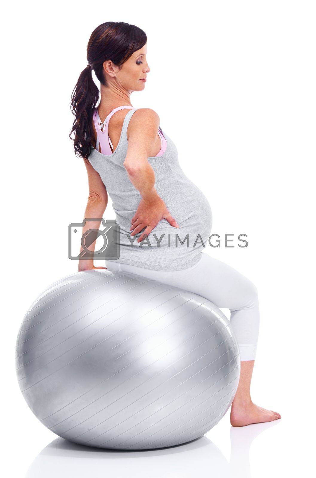Royalty free image of Making sure her back is supported. A pregnant mother sitting on a pilates ball. by YuriArcurs