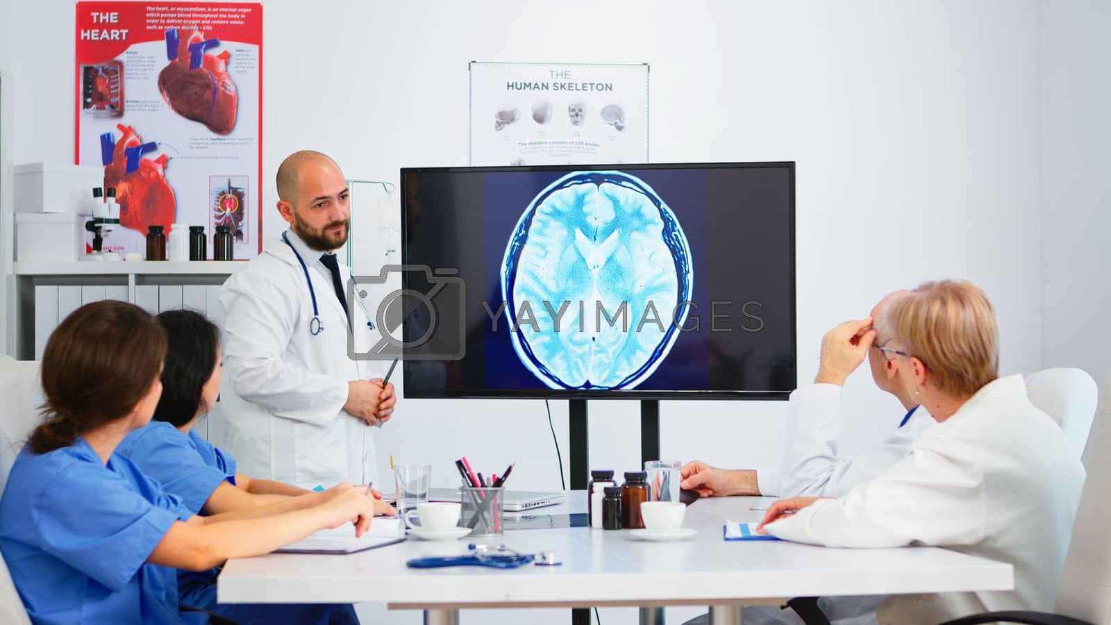Royalty free image of Team of doctors analysing digital x-ray during brainstorming by DCStudio