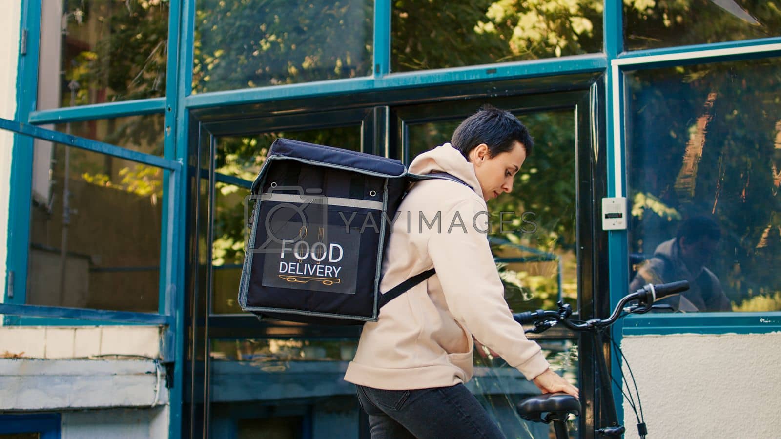Royalty free image of Courier on bicycle delivering food order package by DCStudio