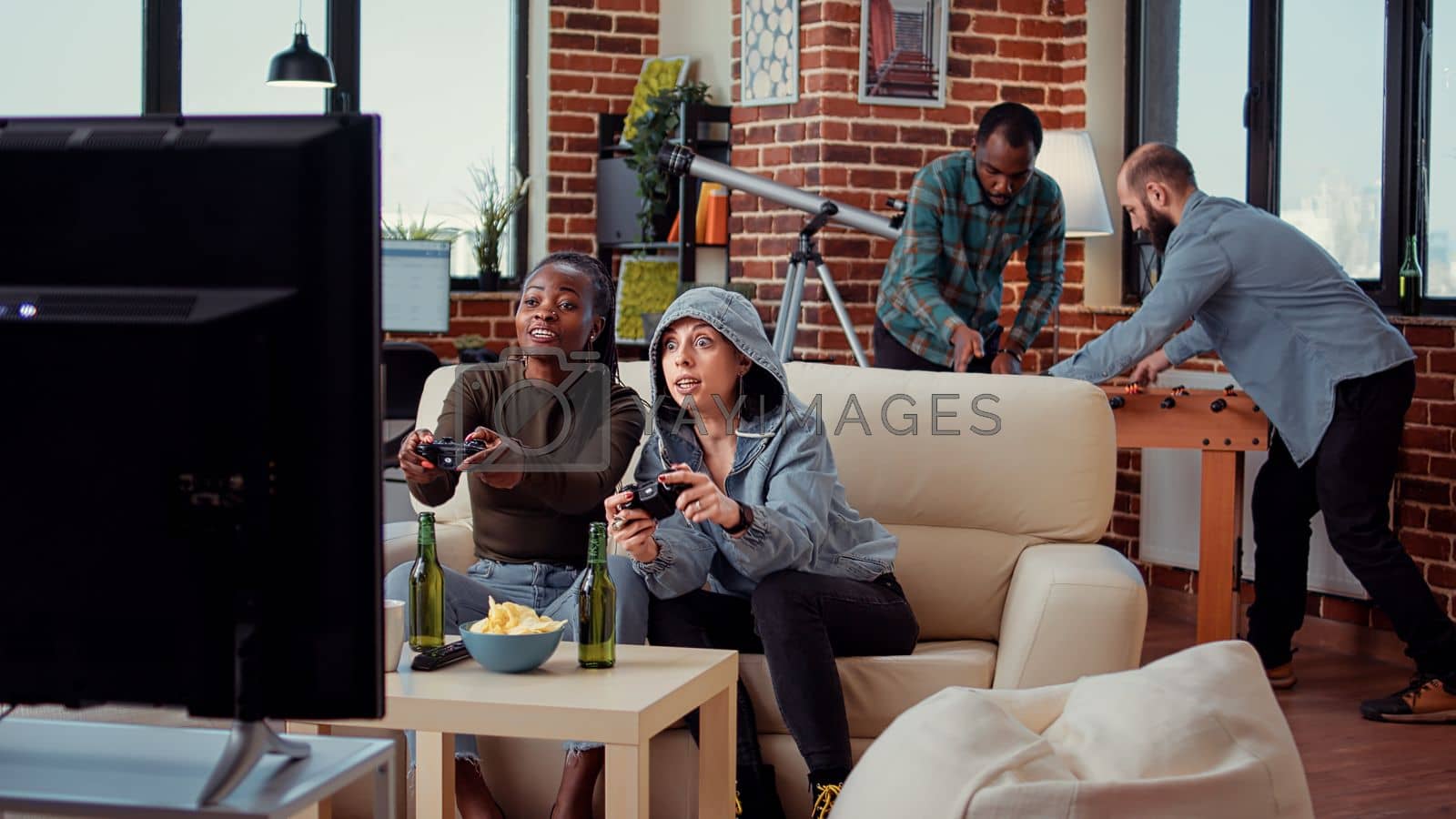 Royalty free image of Diverse team of women playing video games on tv console by DCStudio