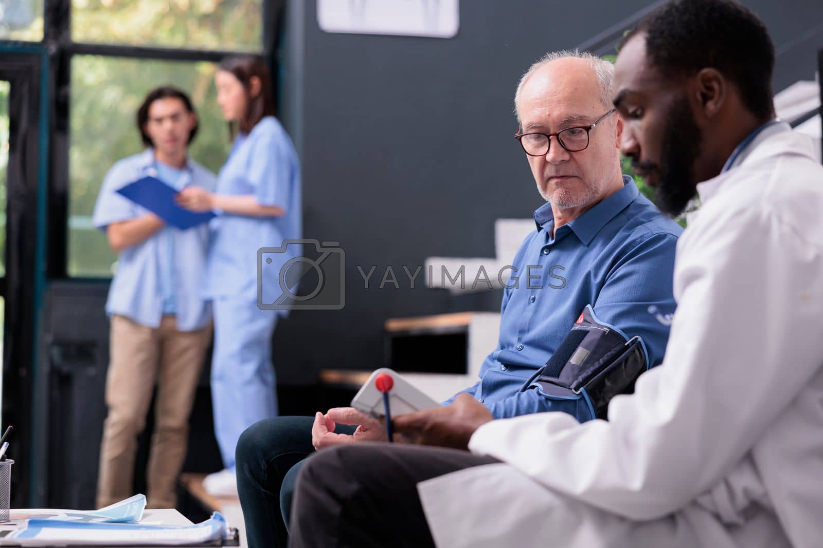 Royalty free image of Cardiologist doctor measuring blood pressure and hypertension with tonometer instrument during consultation by DCStudio