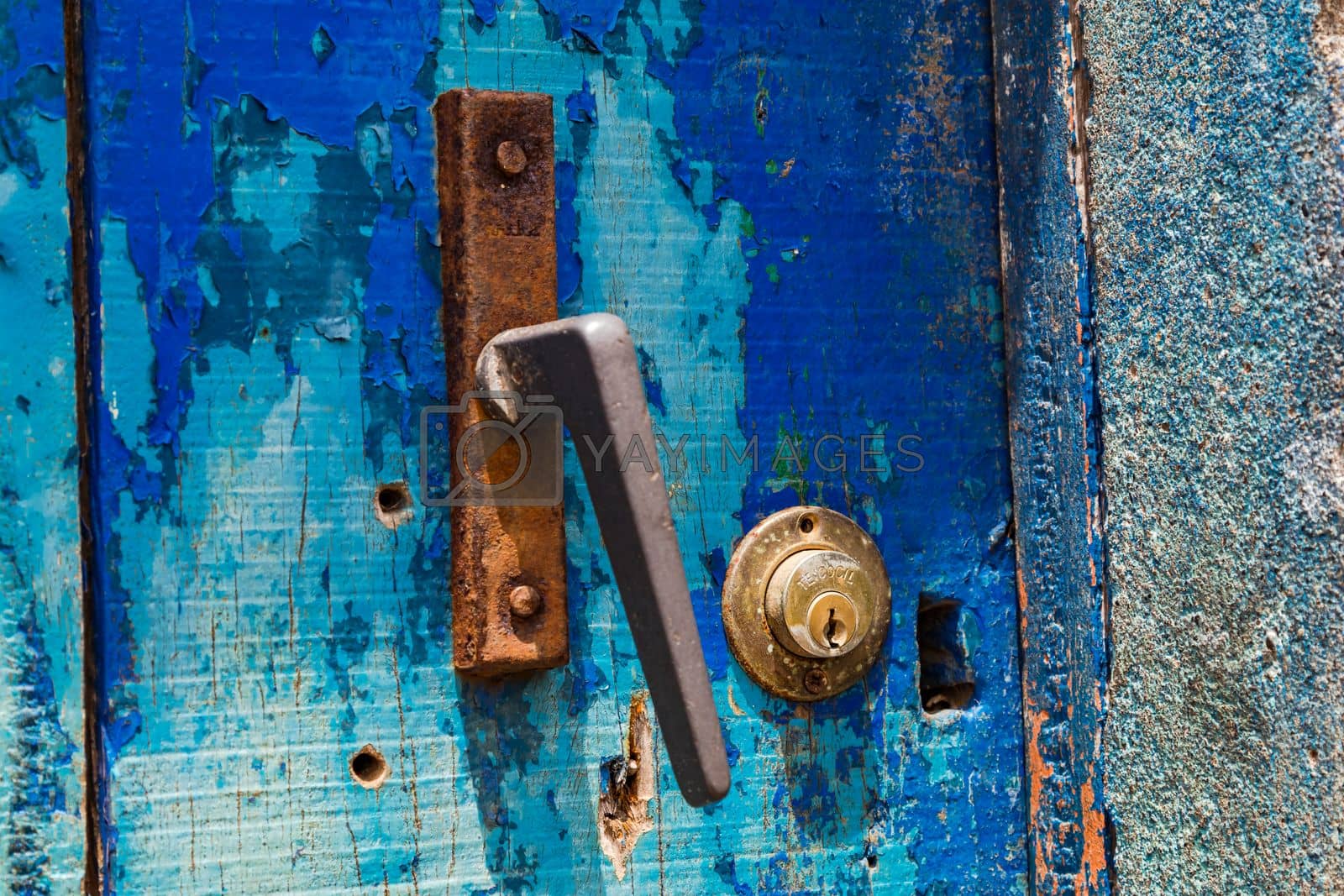 Royalty free image of A blue wooden door with a lock and a rusty doorknob, Cape Verde by astrosoft