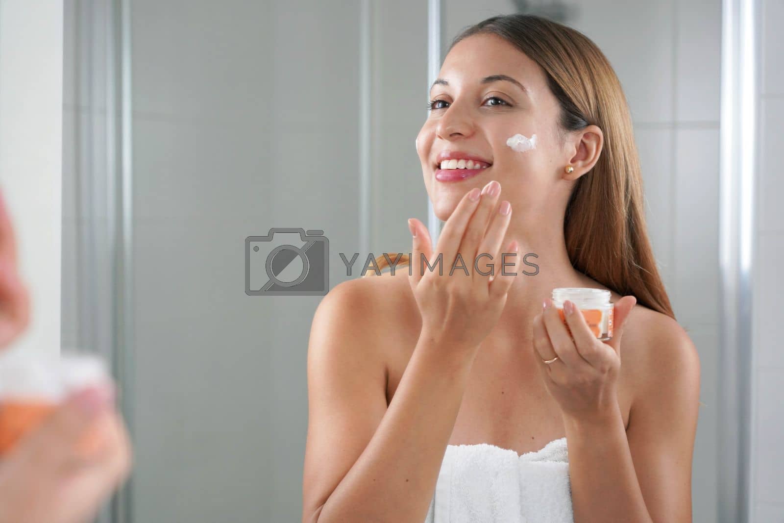 Royalty free image of Skincare woman applying cream on her cheek. Face moisturizing nourishing invigorating treatments. Enjoying relaxing time. by sergio_monti