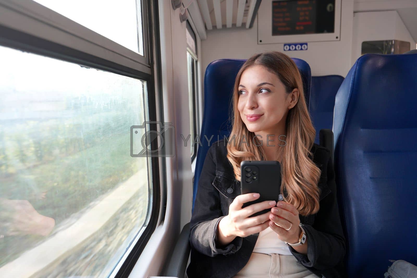 Royalty free image of Beautiful woman traveling with train holding smartphone sitting and relaxed  by sergio_monti