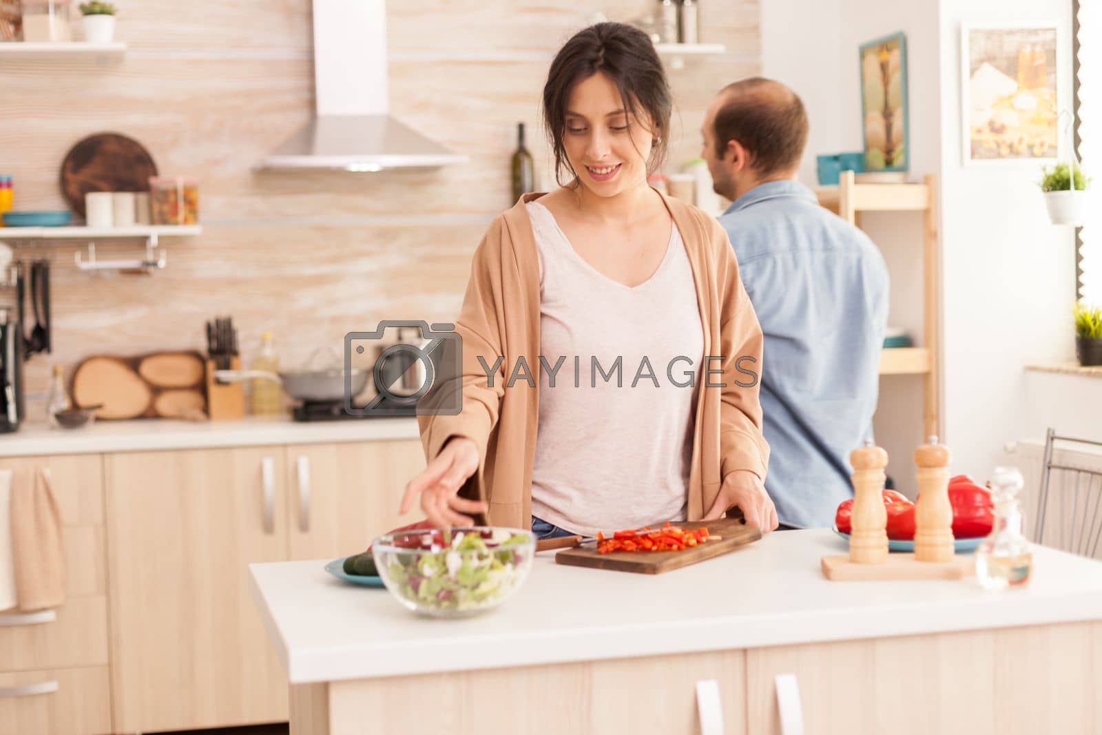 Royalty free image of WIfe reaching out for salad bowl by DCStudio