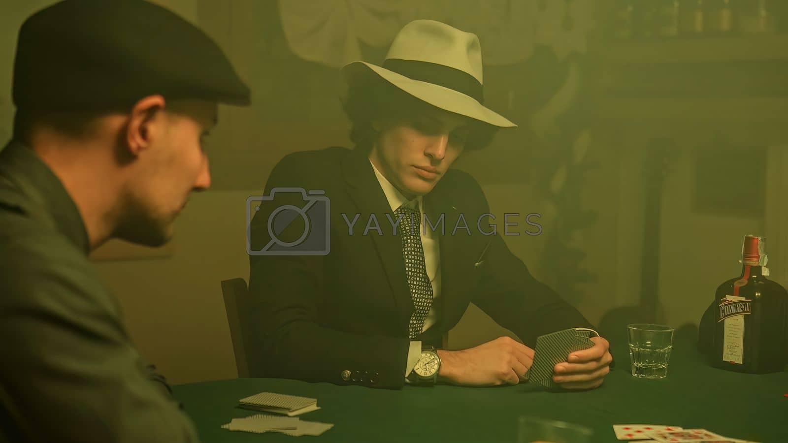 Royalty free image of A defeated poker player stares down at his cards and drops them on the table by pippocarlot