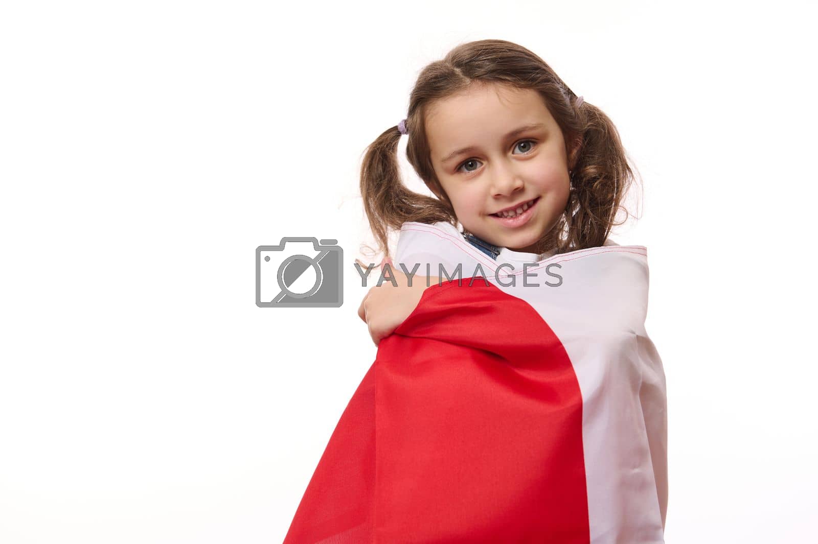 Royalty free image of Beautiful child girl proudly wrapping in flag of Poland or Canada. Concept of national holidays and patriotic events by artgf
