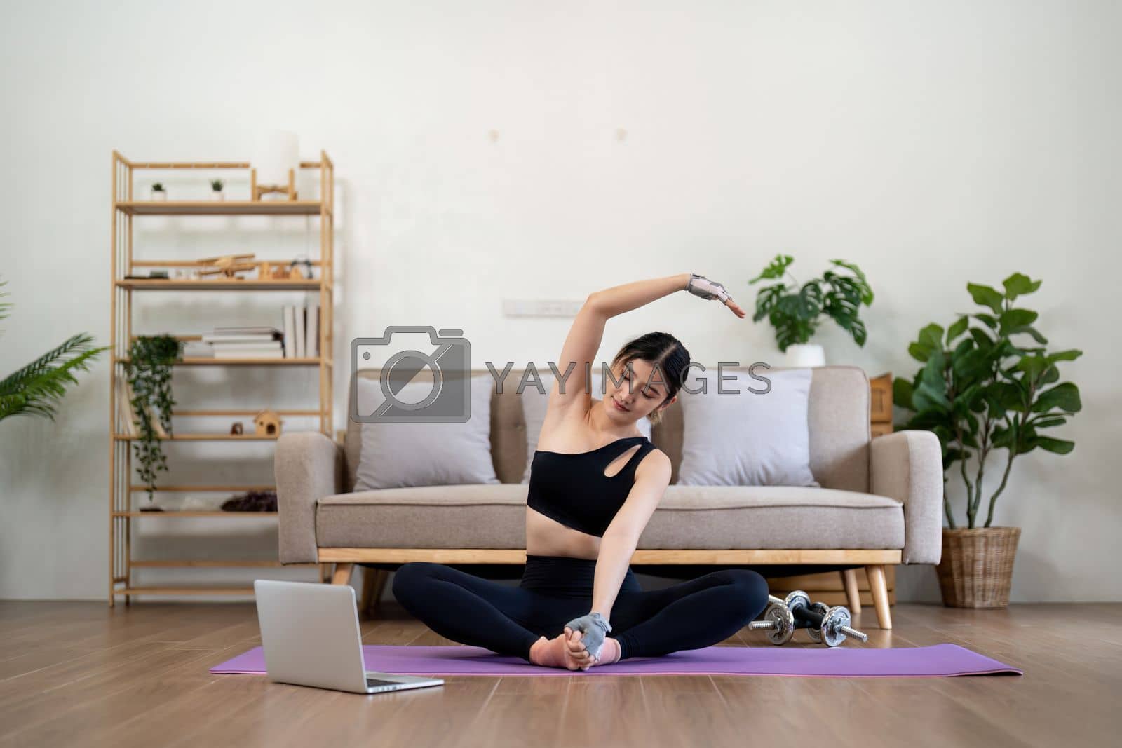 Fit asian woman training fitness exercise sport workout online class on laptop computer at home.