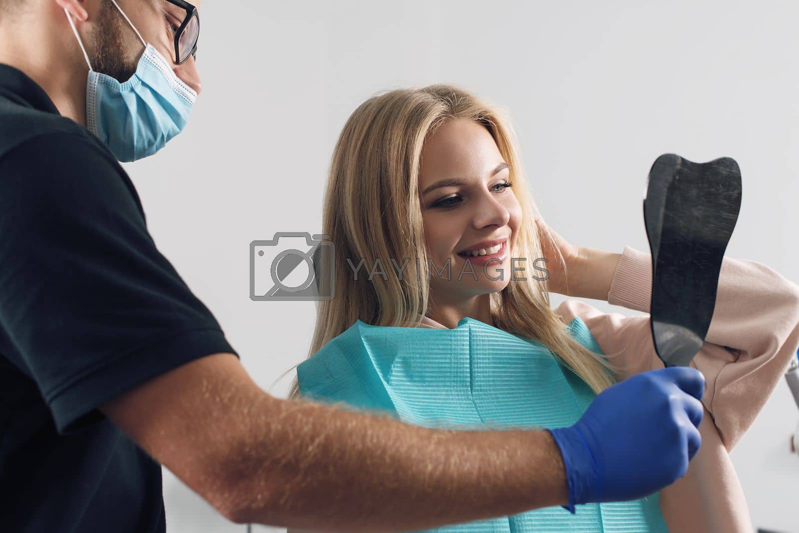 Royalty free image of Portrait of a dentist who treats teeth of young woman patient. by Ashtray25