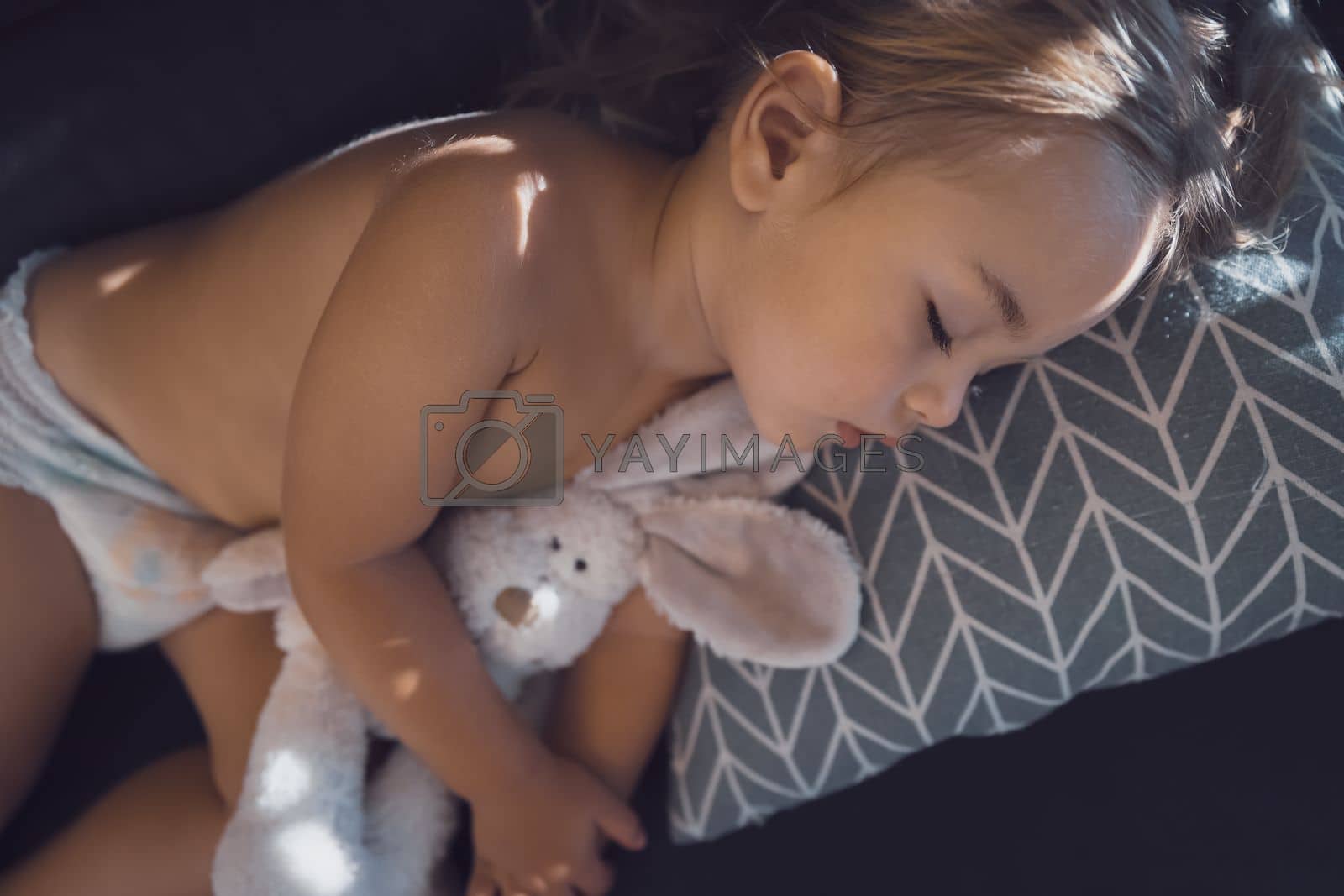 Royalty free image of Pretty baby hugs bunny and sleeping by Anna_Omelchenko