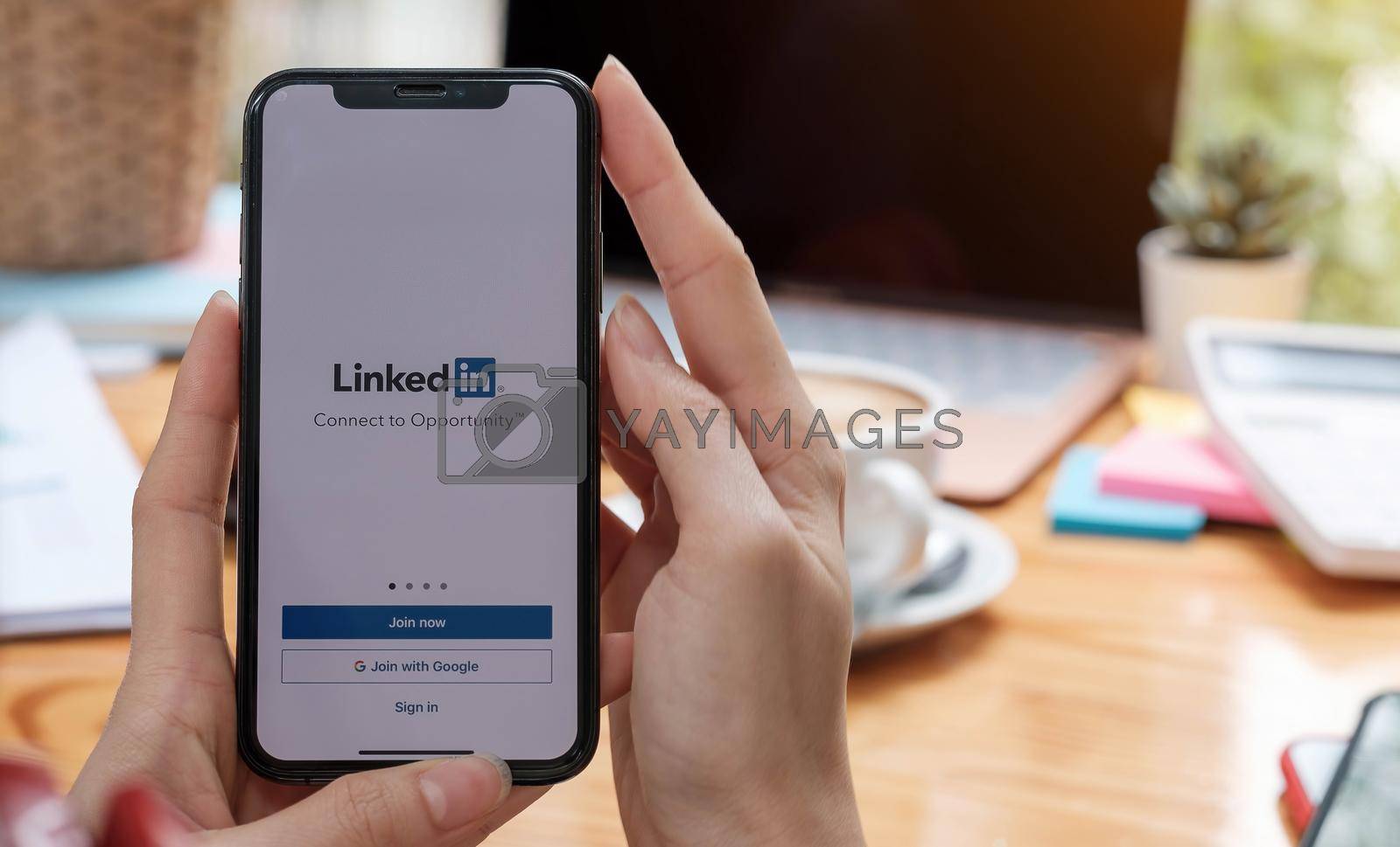 CHIANG MAI, THAILAND, DEC 12, 2020 : A women holds Apple iPhone Xs with LinkedIn application on the screen.LinkedIn is a photo-sharing app for smartphones..