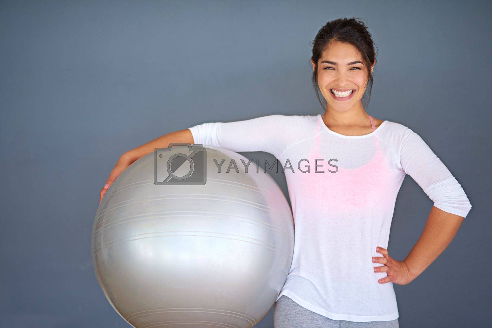 Royalty free image of Every day is a good day when I workout. a sporty young woman holding a pilates ball against a grey background. by YuriArcurs