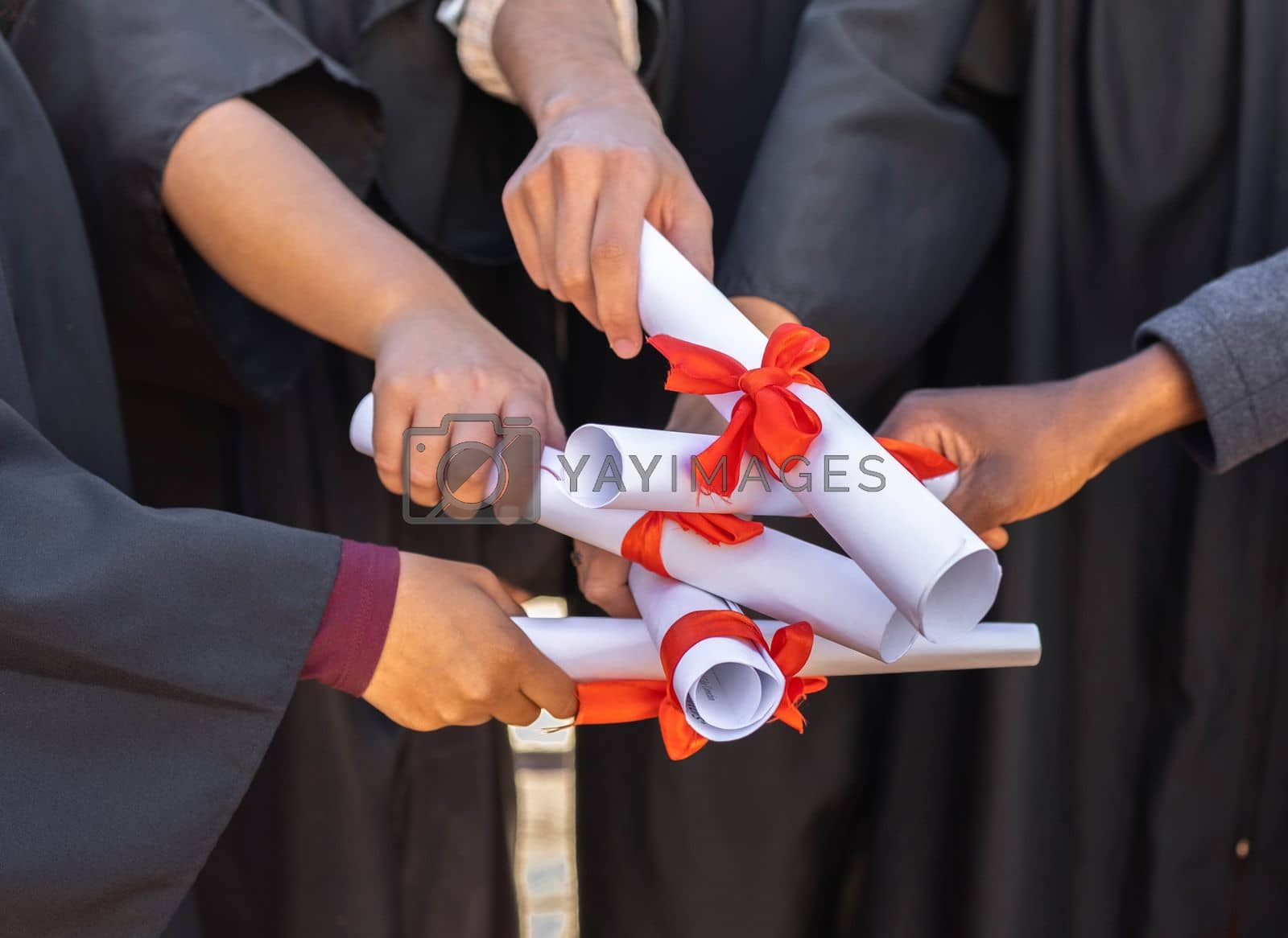 Royalty free image of Graduation, graduate celebration and hands with diploma, together with support, community and college people achievement. University degree, education and learning growth with ceremony and solidarity by YuriArcurs