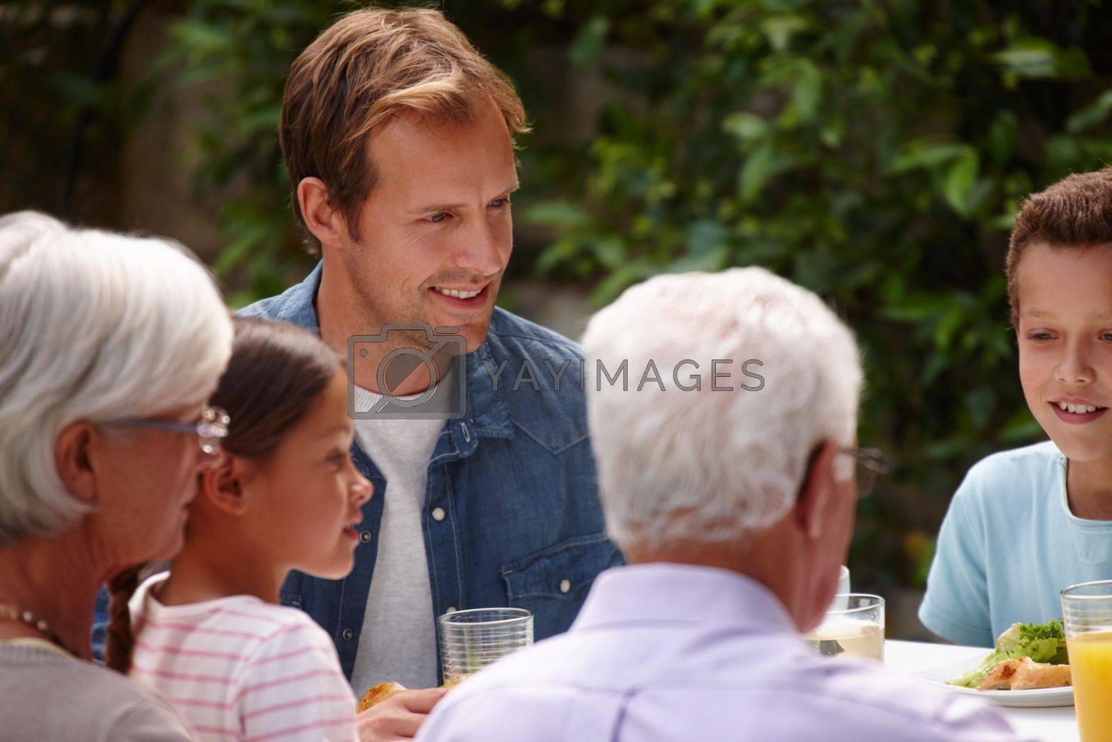 Royalty free image of Sharing a meal as a family. a happy multi-generational family having a meal together outside. by YuriArcurs