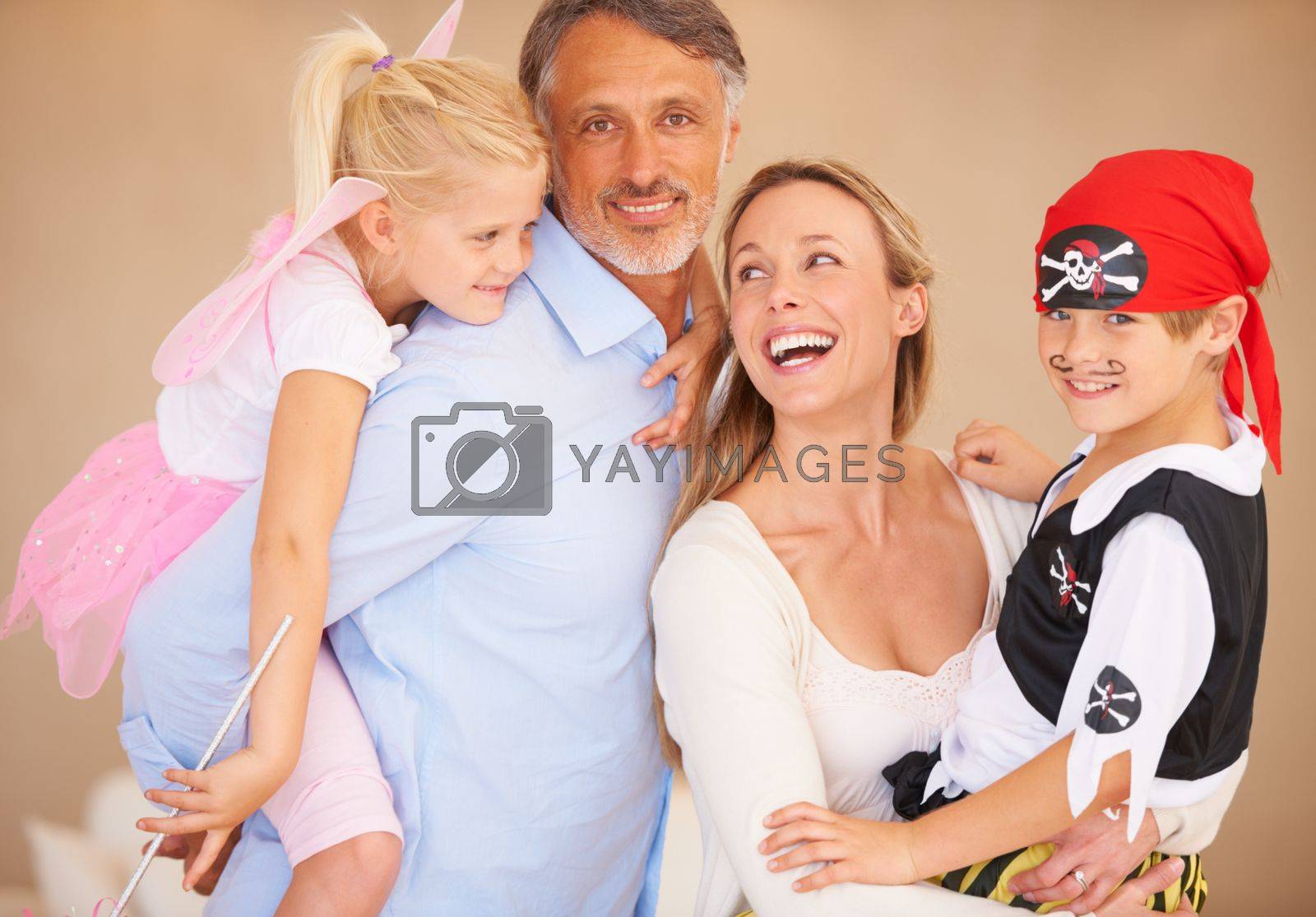 Royalty free image of They love their crazy kids. A family portrait of a father piggybacking his daughter and bother carrying her son on halloween. by YuriArcurs