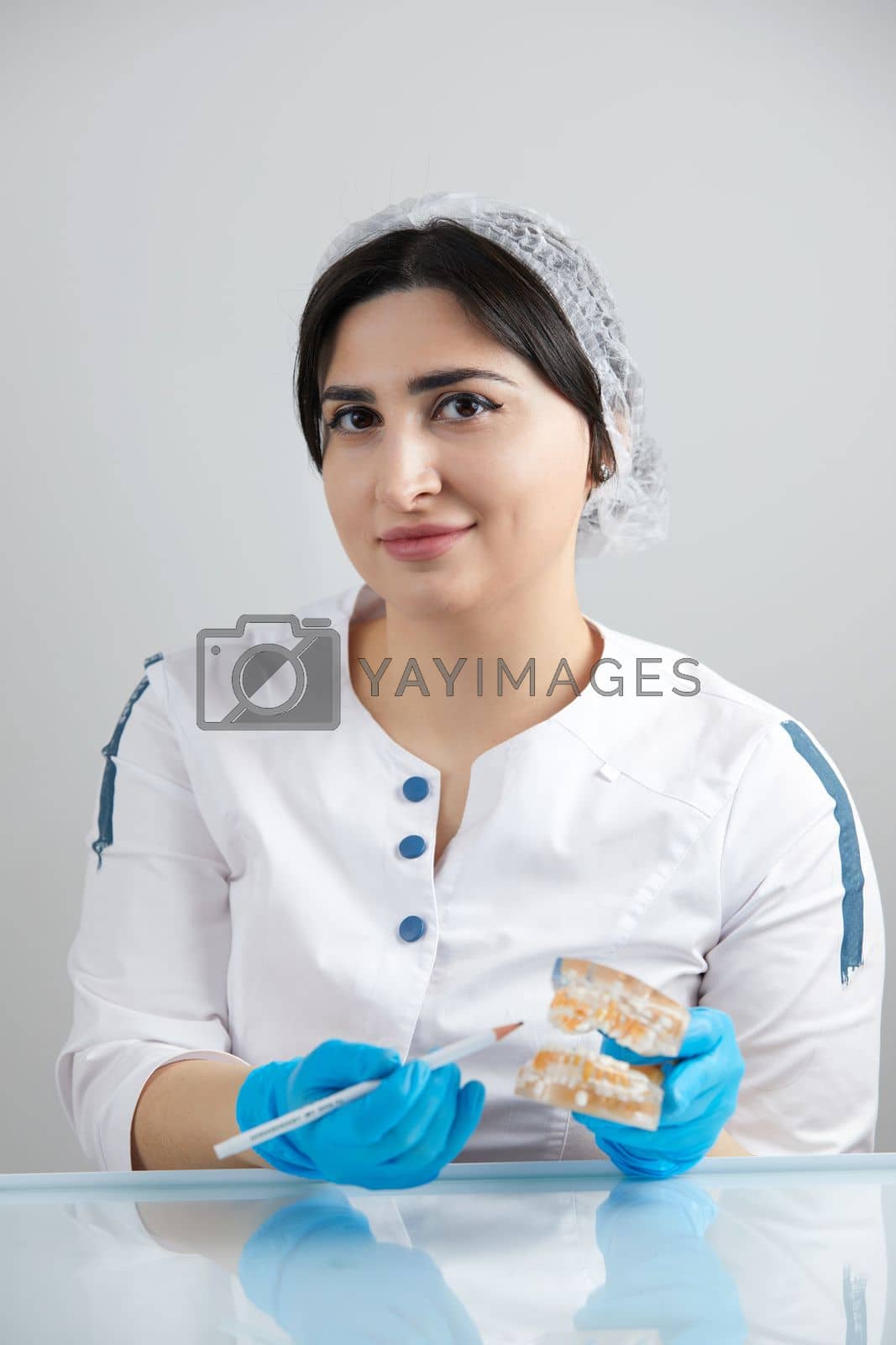 Royalty free image of Dentist showing dental teeth 3d transparent model of jaw by Mariakray