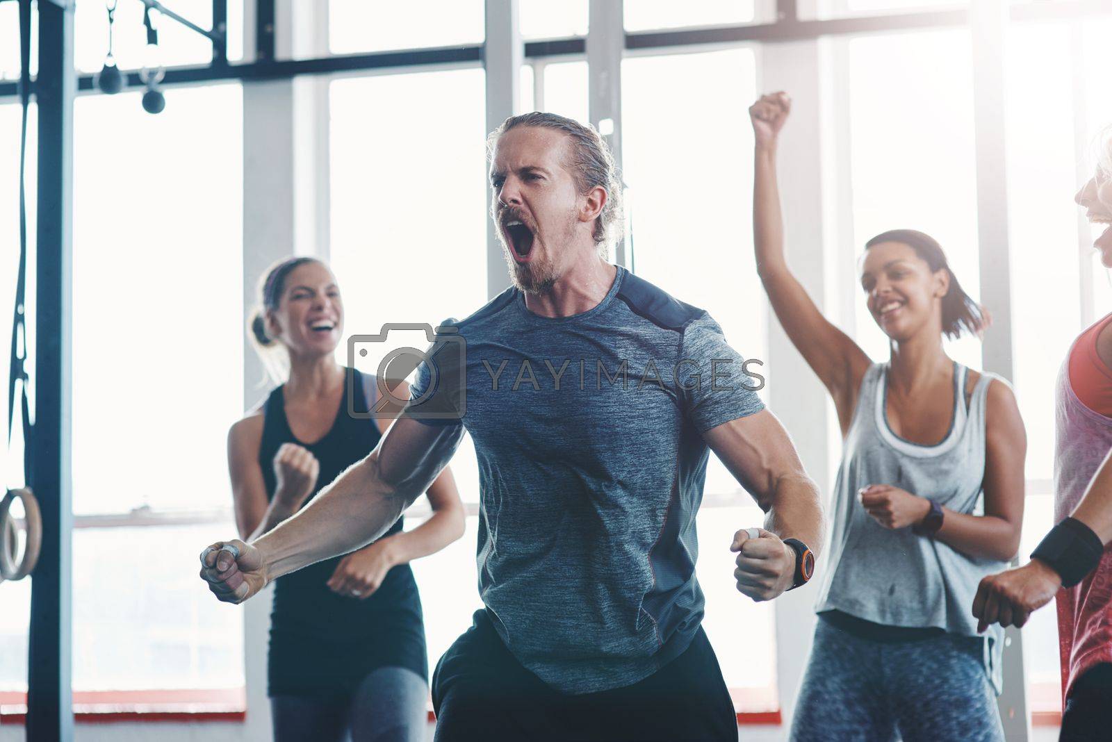 Royalty free image of Hes a beast. a fitness group celebrating a victory at the gym. by YuriArcurs