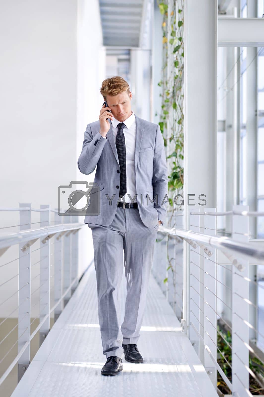 Royalty free image of Connecting with a client. Full length image of a handsome businessman talking on a cellphone. by YuriArcurs