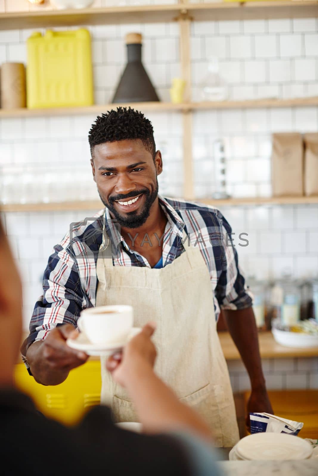Royalty free image of Giving you some happiness in a cup. a handsome young man serving a customer in his coffee shop. by YuriArcurs
