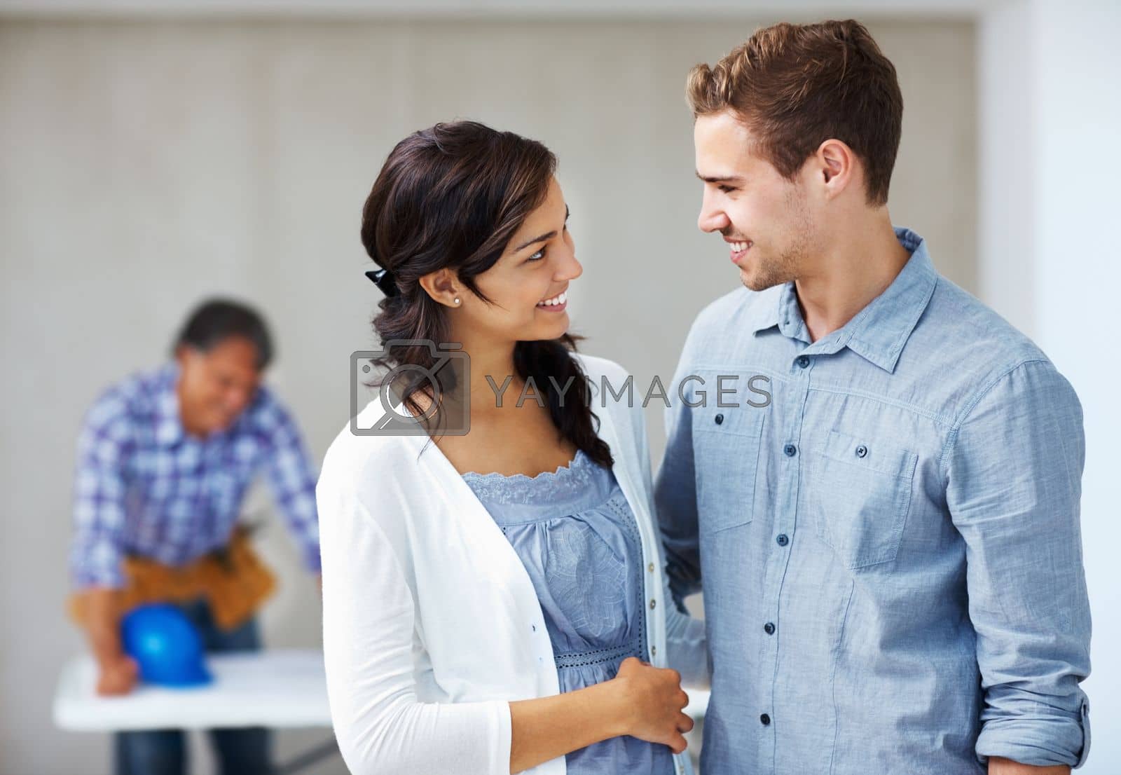Royalty free image of Smiling young couple with architect in background. Closeup of smiling young couple with architect in background. by YuriArcurs