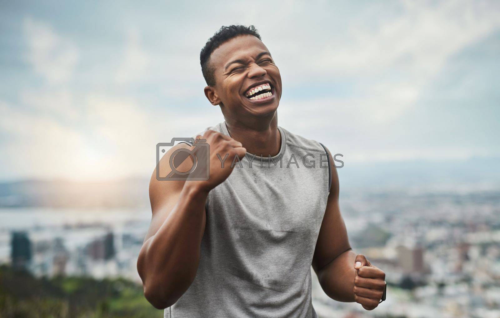 Royalty free image of Hes impressed with himself. a handsome young sportsman cheering in celebration outside. by YuriArcurs