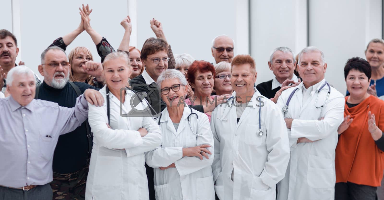 Royalty free image of Happy doctors standing in corridor with team at hospital with crossed arms looking at camera by asdf
