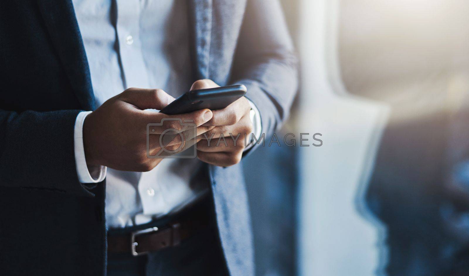 Royalty free image of Communication is always key. Closeup shot of an unrecognizable businessman using a cellphone in an office. by YuriArcurs