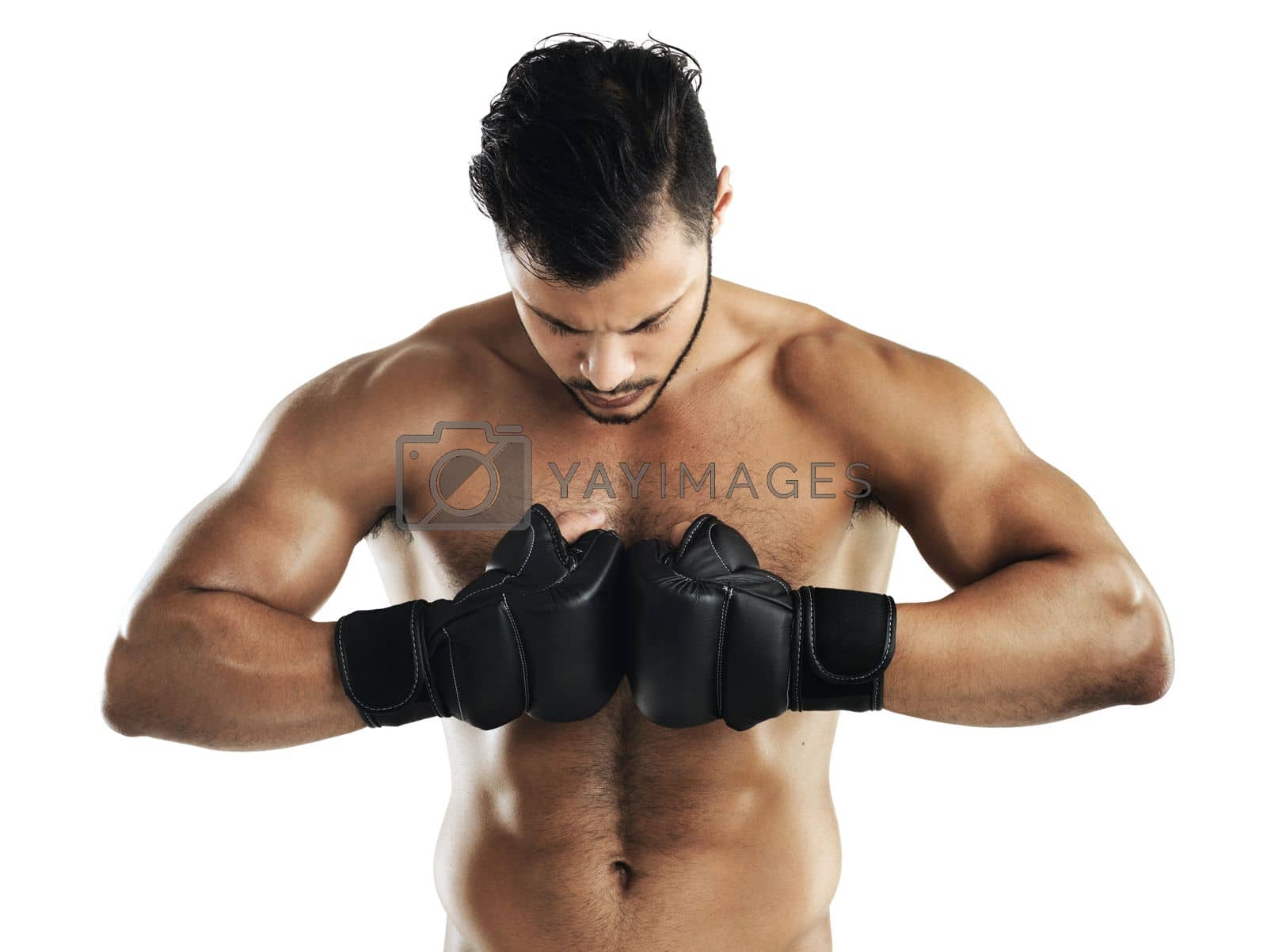 Royalty free image of Hes in it to win it. Studio shot of a fit young man wearing boxing gloves against a white background. by YuriArcurs
