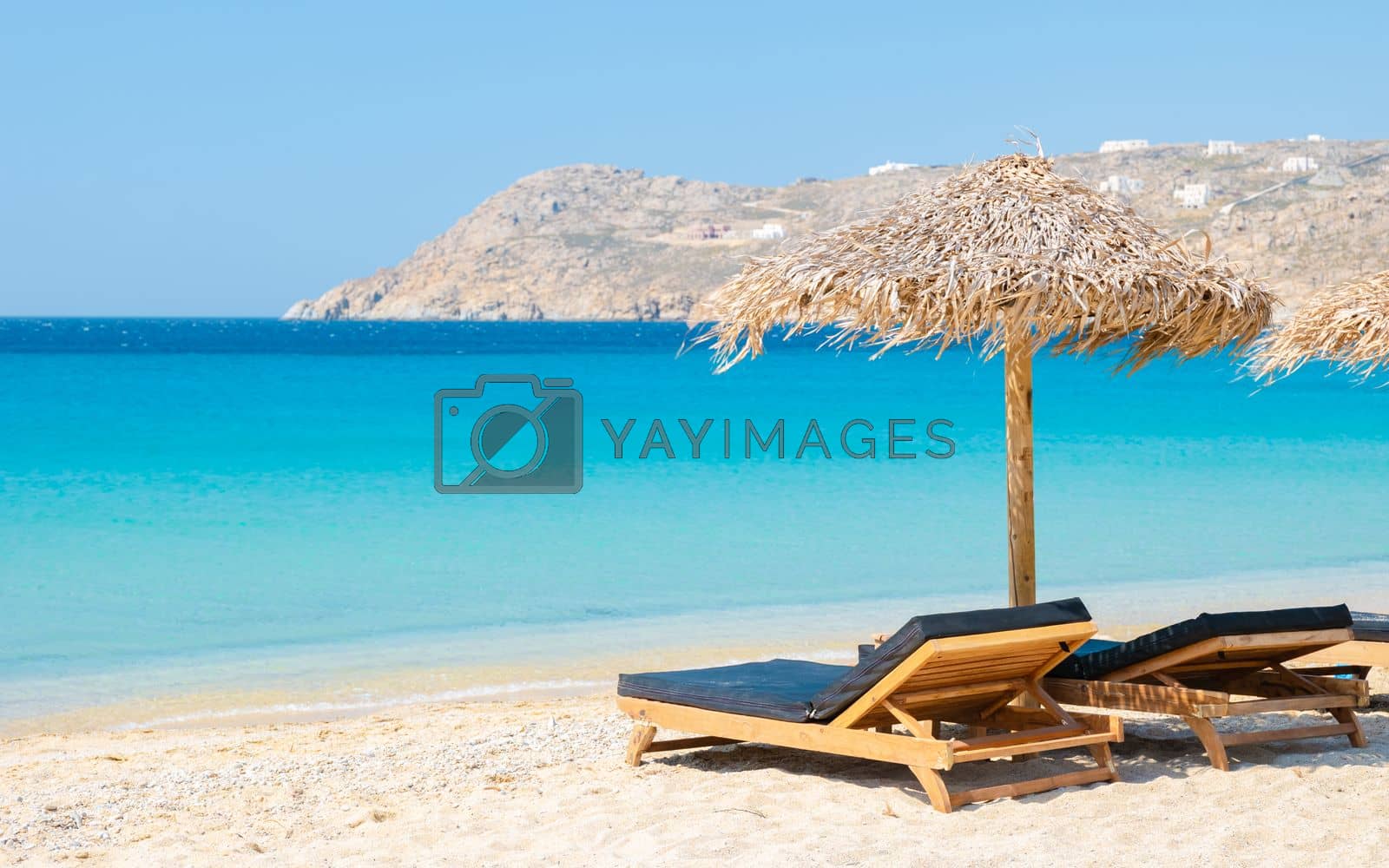 Royalty free image of Mykonos beach during summer with umbrella and luxury beach chairs beds, blue ocean at Elia beach by fokkebok