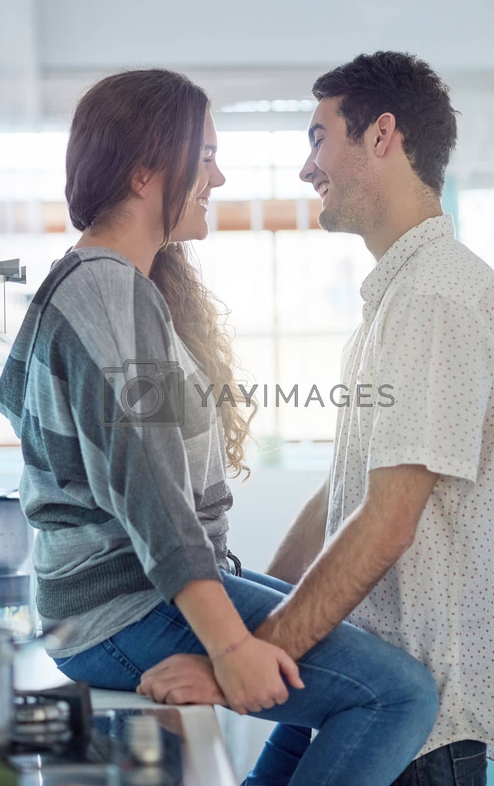 Royalty free image of They never tire of each others company. a young couple having fun in the kitchen while relaxing at home. by YuriArcurs