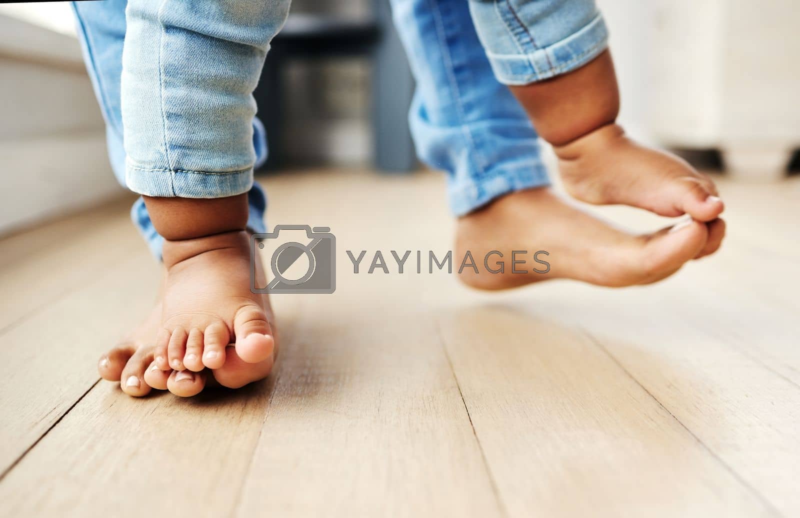 Royalty free image of One step at a time. a mother helping her baby learn to walk. by YuriArcurs