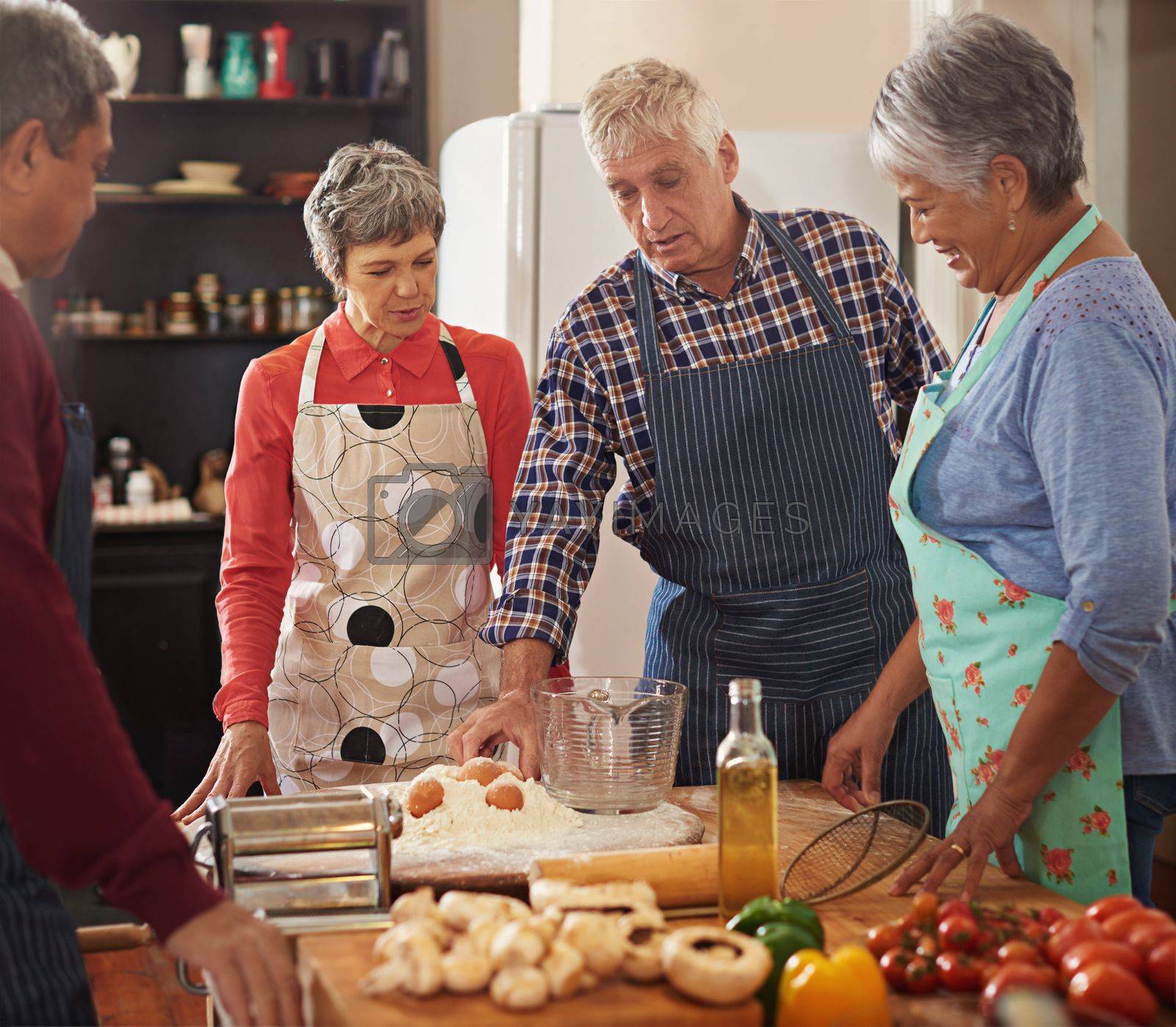 Royalty free image of Keep calm and cook on. a group of seniors cooking in the kitchen. by YuriArcurs