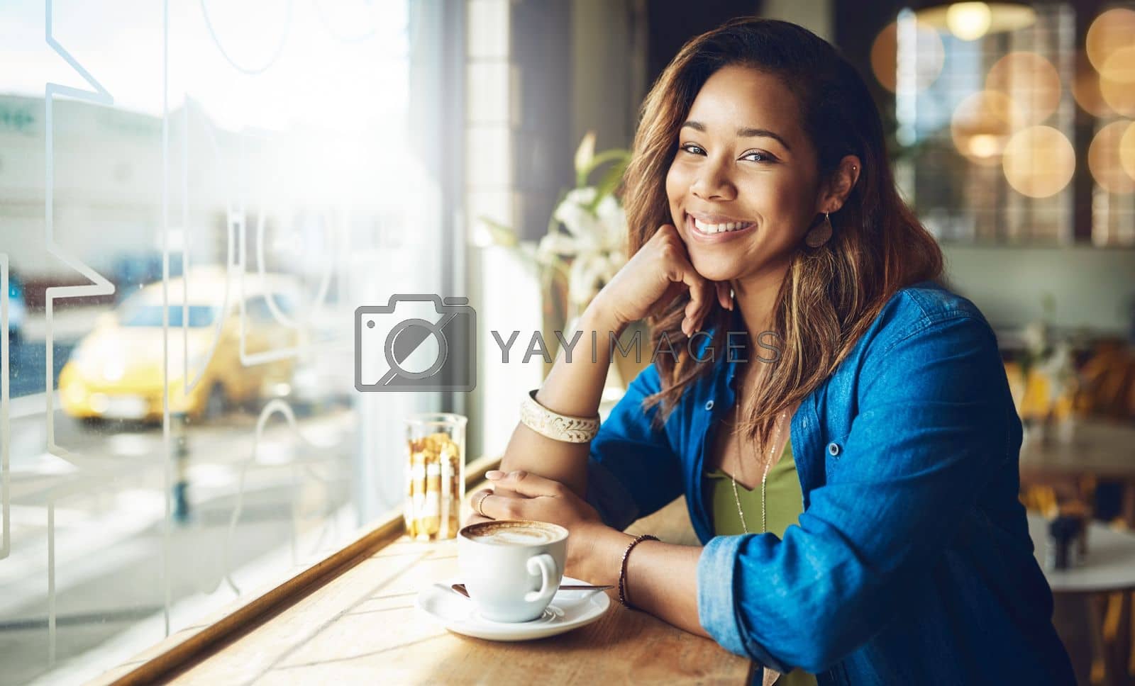 Royalty free image of This is the best spot for coffee. a beautiful young woman sitting in a cafe. by YuriArcurs