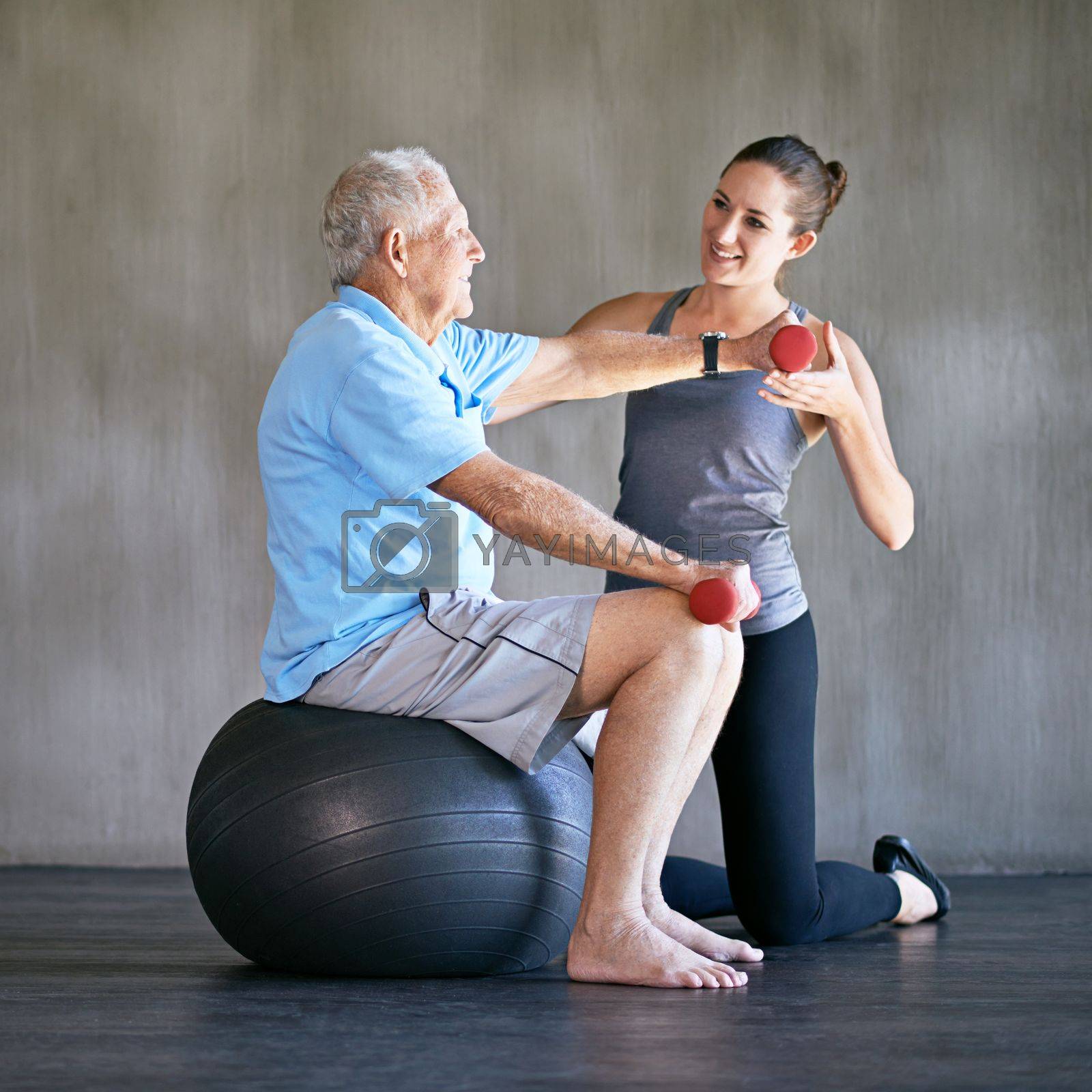 Royalty free image of Treating the patient and the injury. a a physical therapist working with a senior man. by YuriArcurs