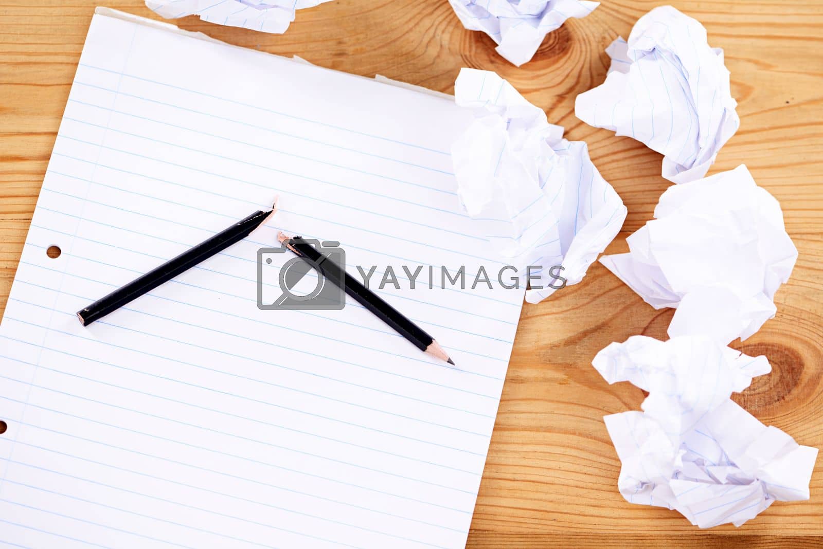 Writers block. a broken pencil and notepad surrounded by crumpled paper