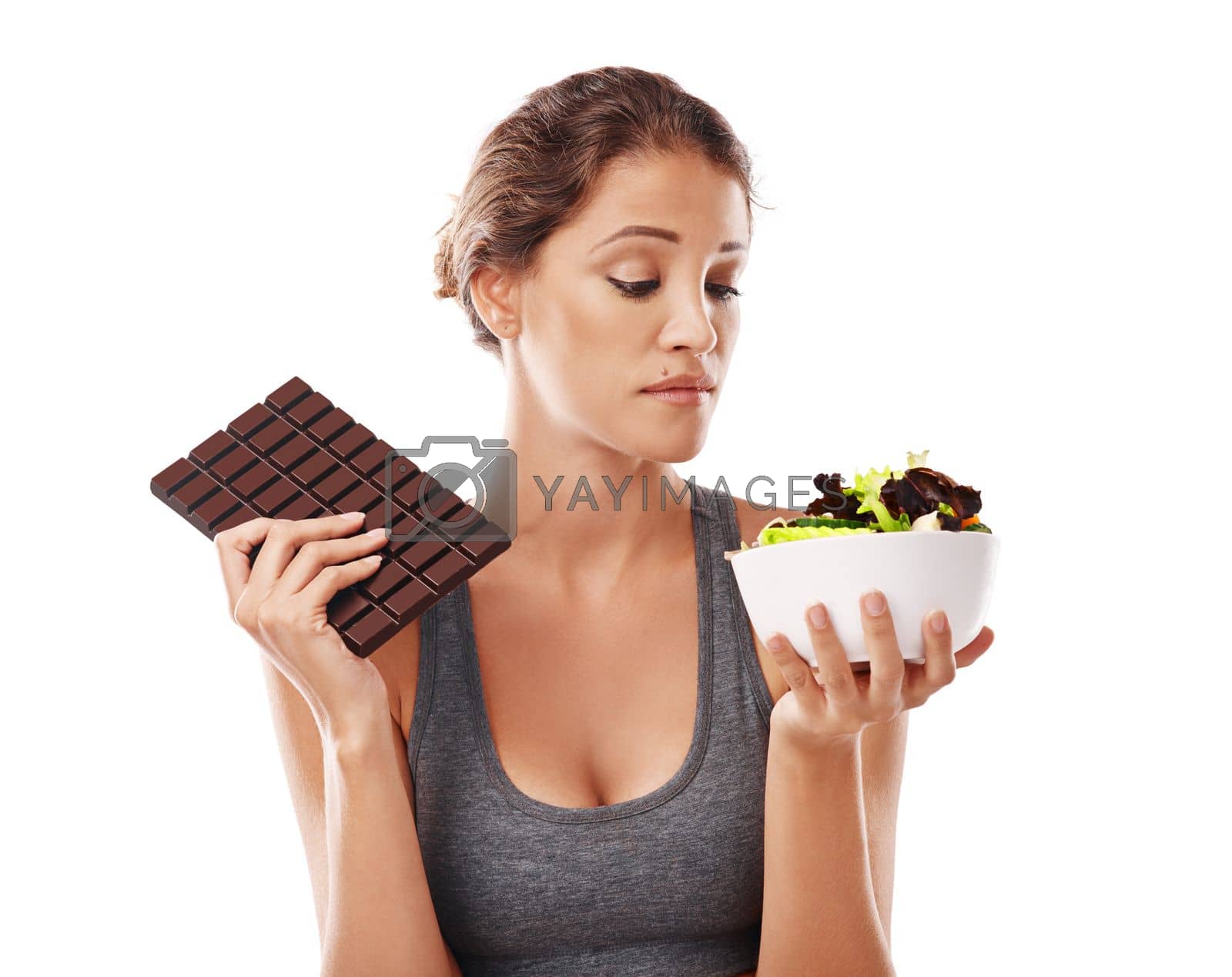 Royalty free image of Youre either fighting a disease or feeding it. Studio shot of an attractive young woman deciding between healthy and unhealthy foods. by YuriArcurs