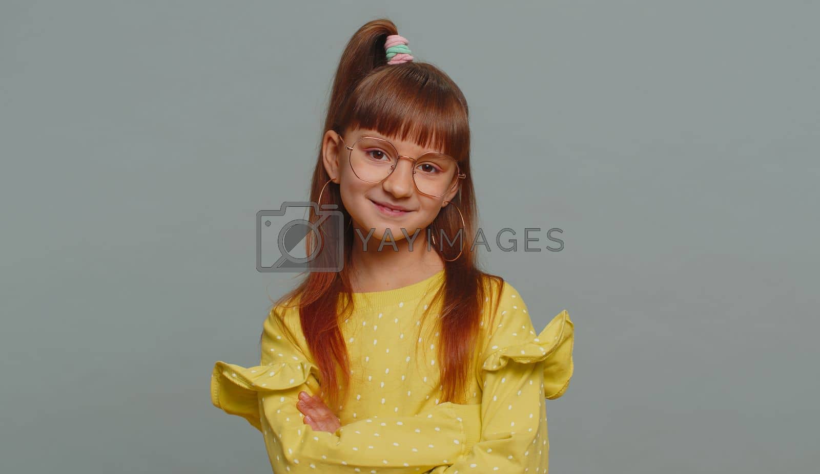 Royalty free image of Cheerful lovely young preteen child girl kid smiling, looking at camera on studio gray background by efuror