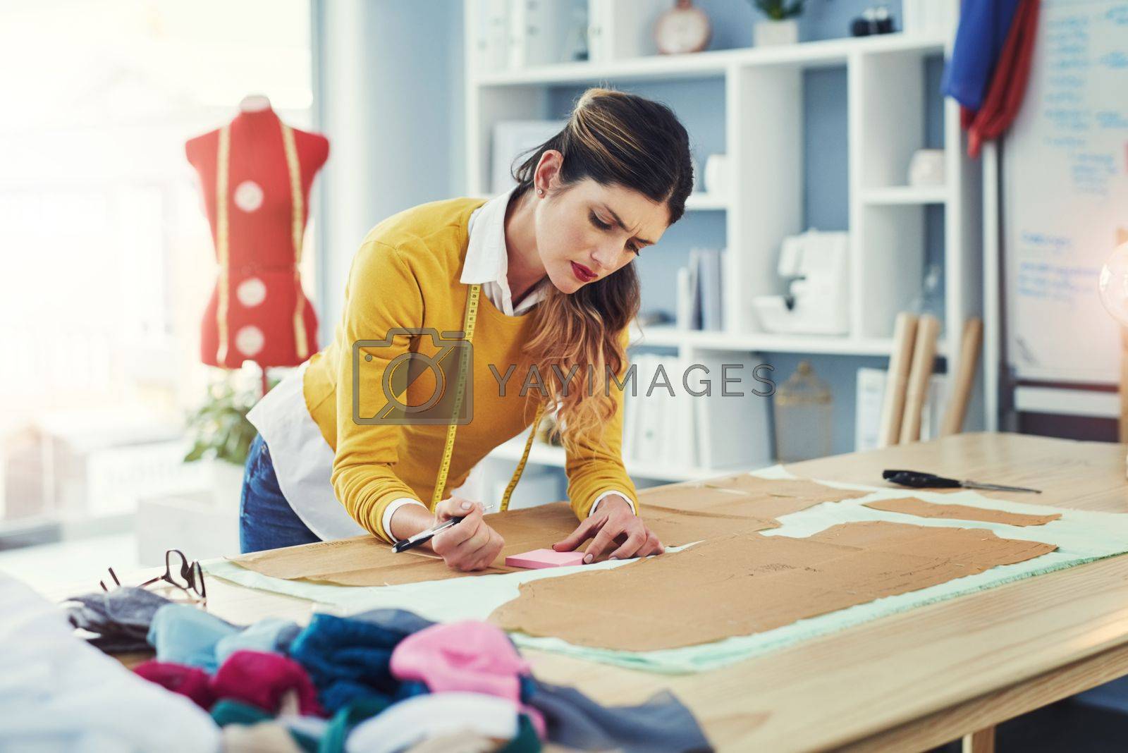 Royalty free image of Play around with your designs. an attractive young fashion designer in her workshop. by YuriArcurs