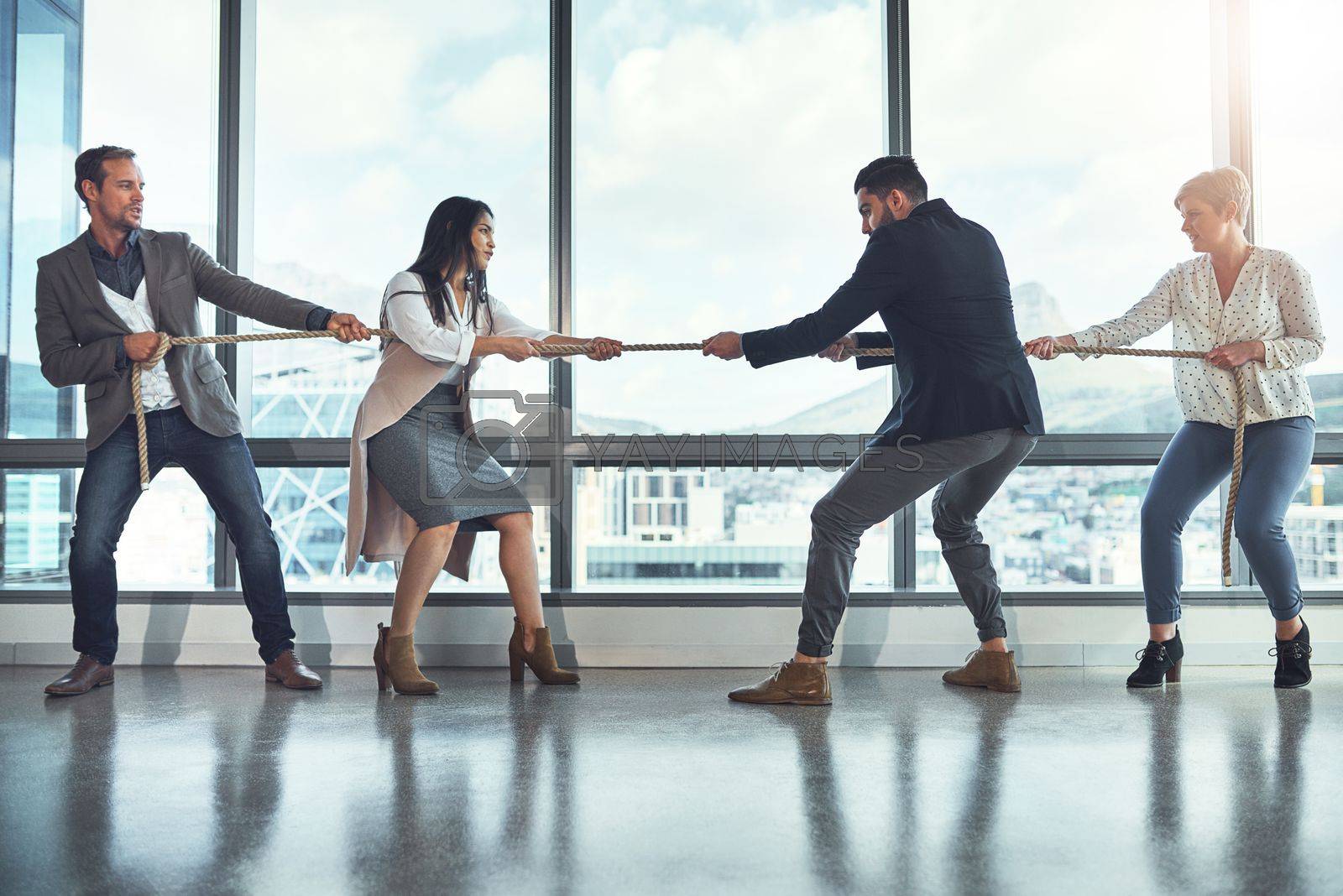 Royalty free image of The business world is quite a competitive one. a group of businesspeople pulling on a rope during tug of war in an office. by YuriArcurs