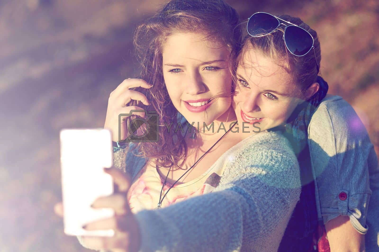 Royalty free image of Capturing best friend moments. two teenage girls taking a selfie outdoors. by YuriArcurs