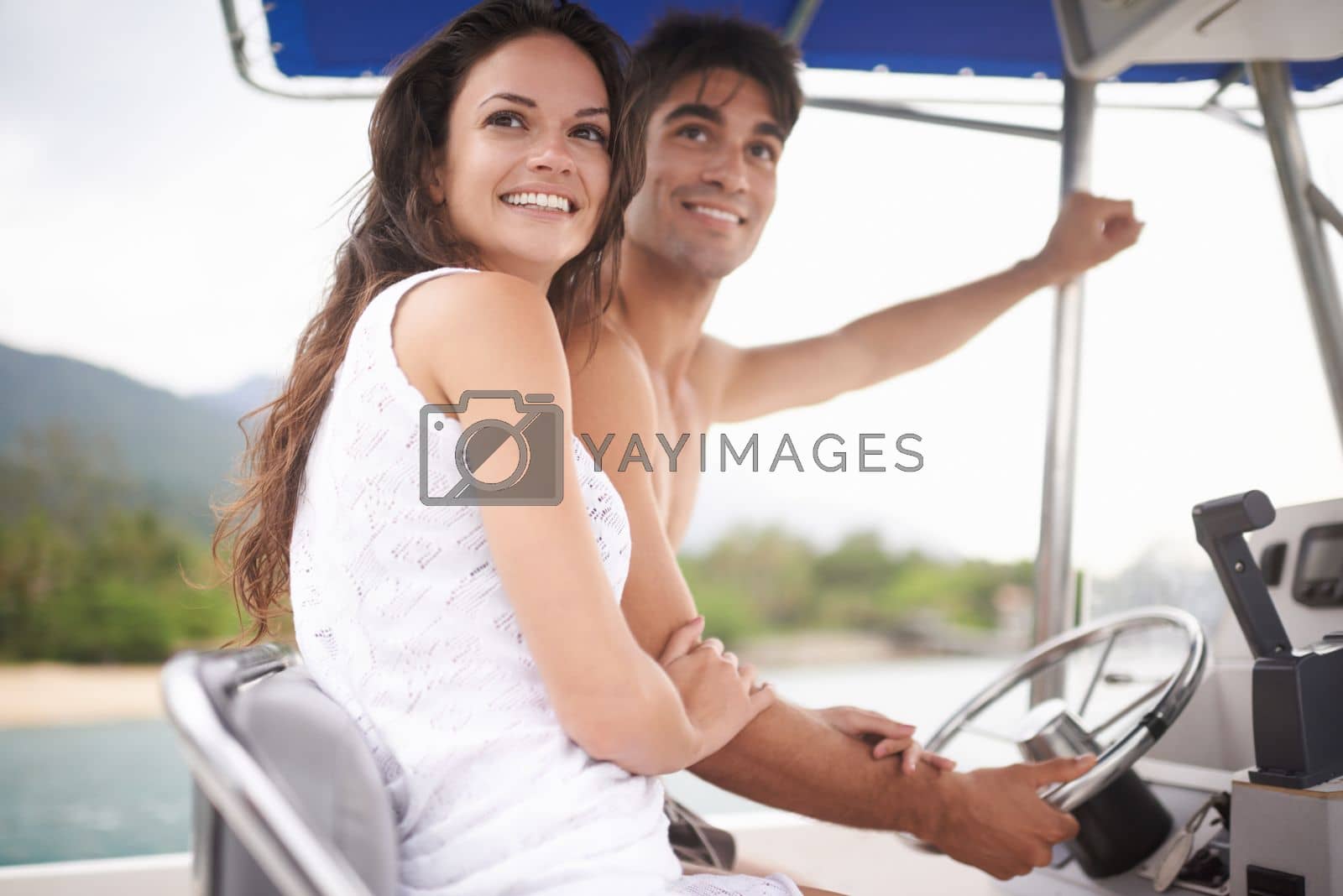 Royalty free image of Living the dream. an affectionate young couple enjoying a boat ride on the lake. by YuriArcurs