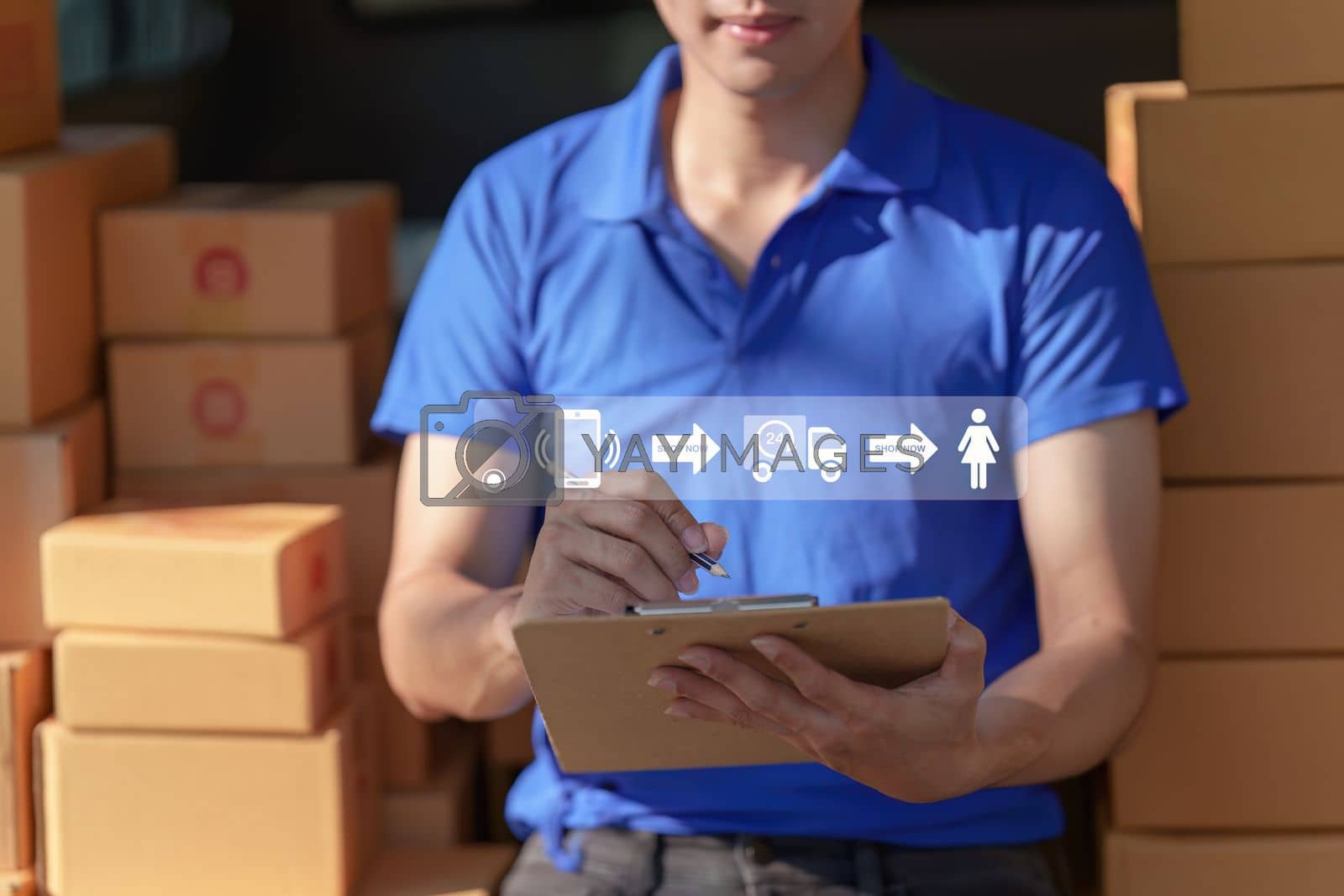 Royalty free image of Asian courier with parcel and delivery logistic concept. Delivery man with checking list on clipboard by itchaznong
